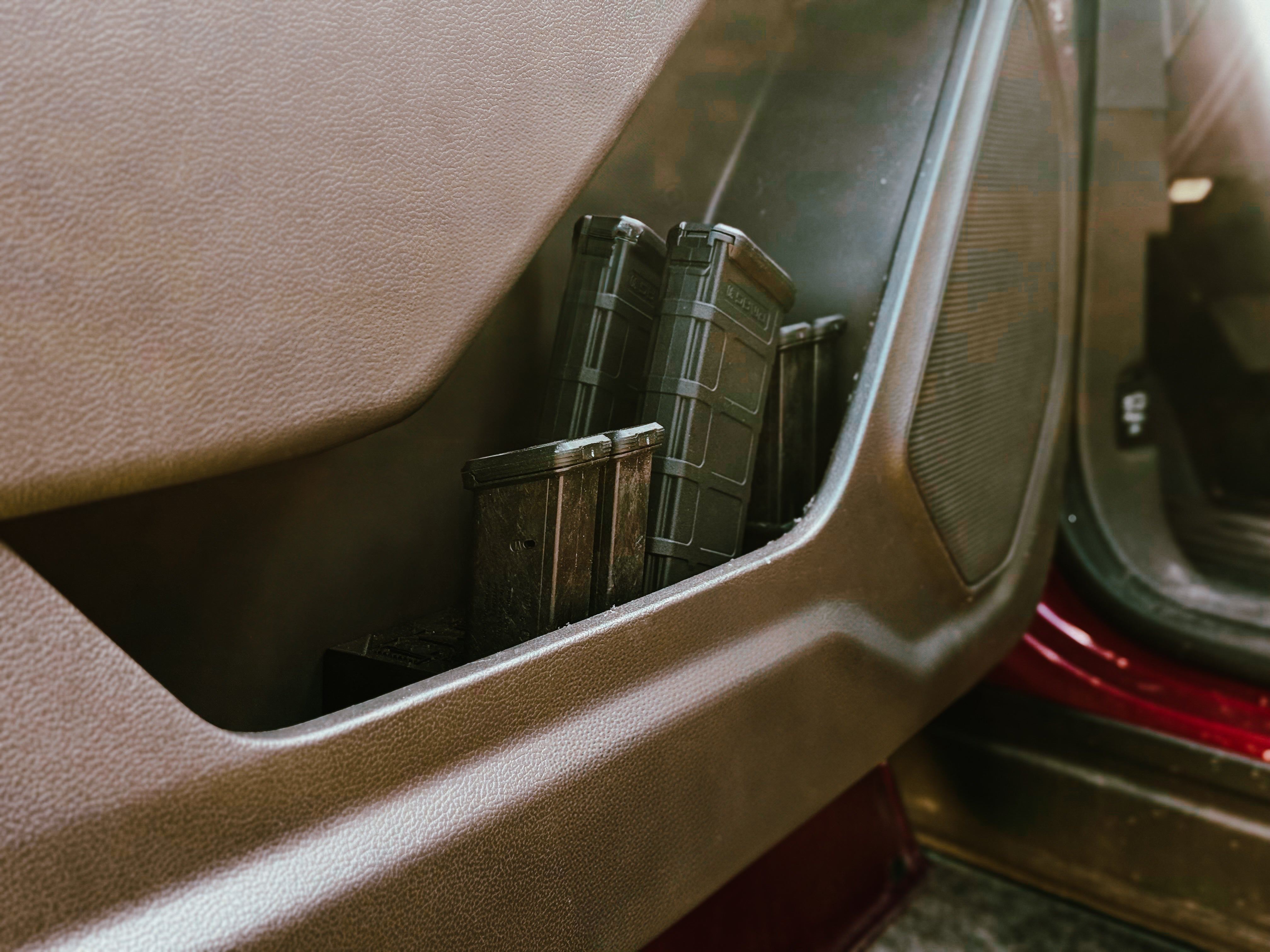 Close-up of a car's door pocket with a Door Mags holster inside.