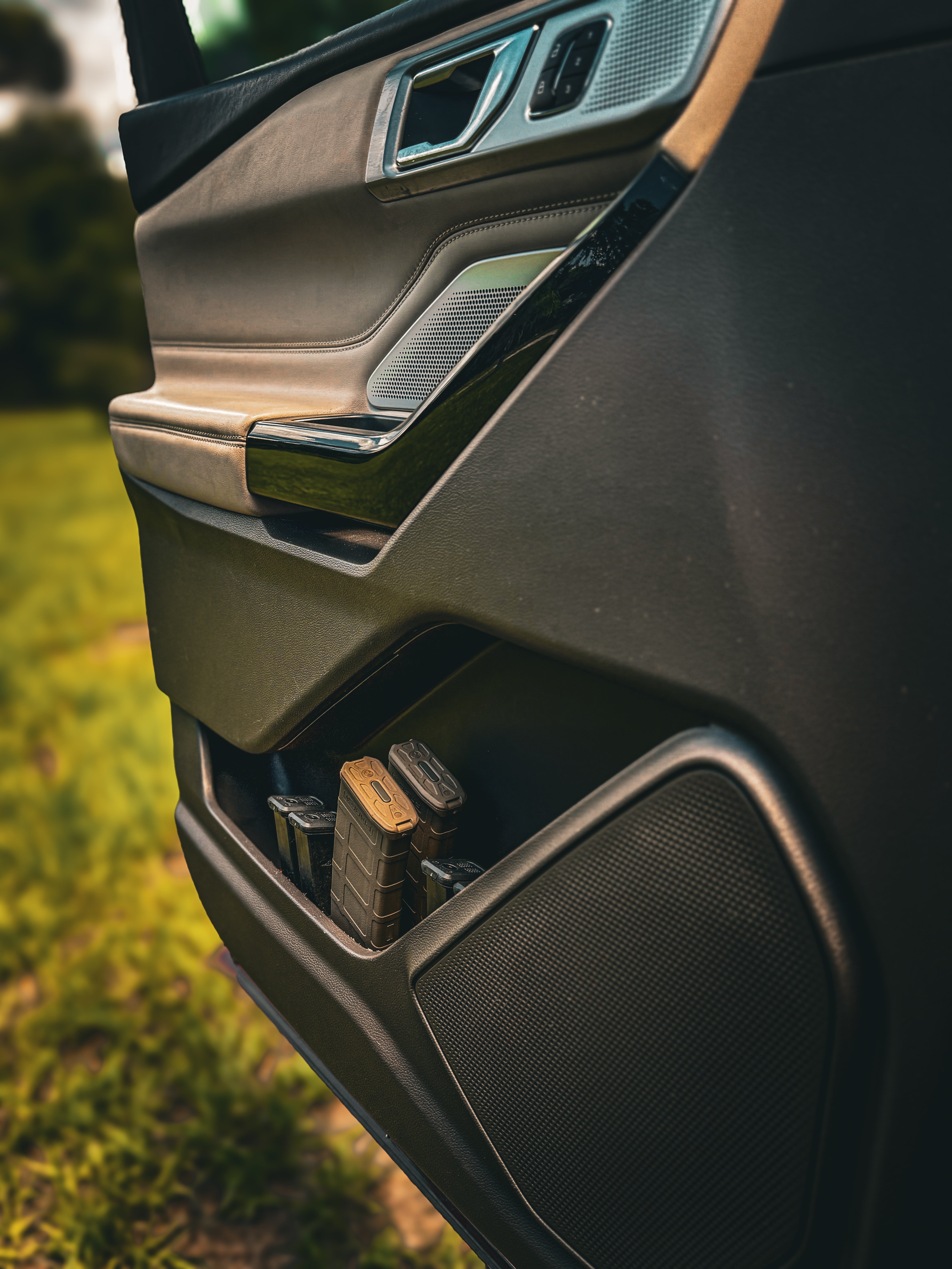 Close-up of a car door with a storage compartment on a grassy background